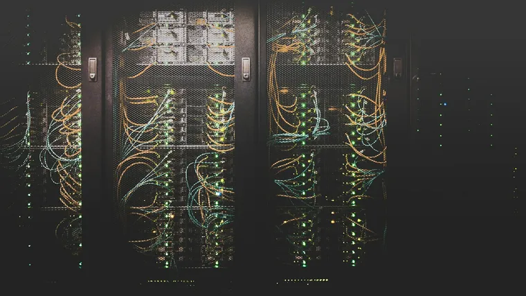Baies de serveurs dans un datacenter, avec des câbles réseau jaunes et bleus et des voyants allumés